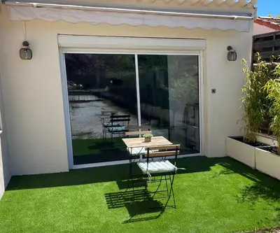 a patio with a table on the grass at La chambre de Cleron in Saint-Laurent-du-Var