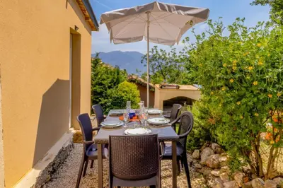 a table and chairs with an umbrella on a patio at Maison Belle Vue & Jardin- Tout à proximité à Pied in Gattières
