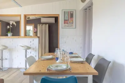 a wooden table with plates and wine glasses on it at Maison Belle Vue & Jardin- Tout à proximité à Pied in Gattières