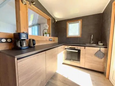 a kitchen with wooden cabinets and a counter top at Maison Belle Vue & Jardin- Tout à proximité à Pied in Gattières