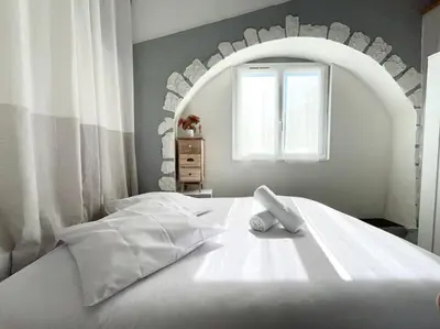 a bedroom with a white bed with a large mirror at Maison Belle Vue & Jardin- Tout à proximité à Pied in Gattières