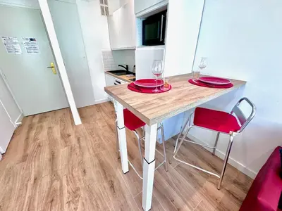 a small kitchen with a table with red plates and wine glasses at #19 Lenval - Balcon Lenval Sea View with AC Promenade des Anglais in Nice