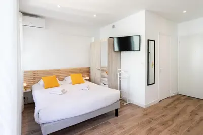 a bedroom with a white bed with two orange pillows at #19 Lenval - Balcon Lenval Sea View with AC Promenade des Anglais in Nice