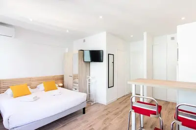 a bedroom with a bed and a table and chairs at #19 Lenval - Balcon Lenval Sea View with AC Promenade des Anglais in Nice