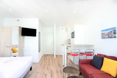 a living room with a red couch and a kitchen at #19 Lenval - Balcon Lenval Sea View with AC Promenade des Anglais in Nice
