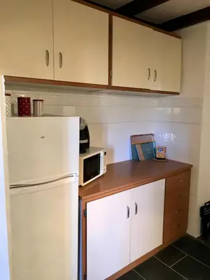 a kitchen with a white refrigerator and a microwave at Petit cocon in Villefranche-sur-Mer