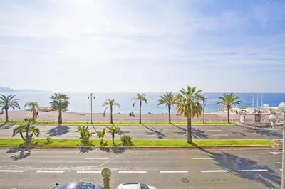 a view of a parking lot with palm trees and the ocean at Luxury Flat Beachfront Nice in Nice