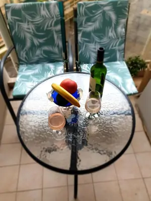 a glass table with a bottle of wine and a pencil at Central place close to the beach AC air , WI FI, parking in Nice