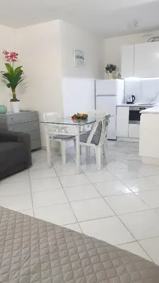 a living room with a table and a kitchen at Central place close to the beach AC air , WI FI, parking in Nice