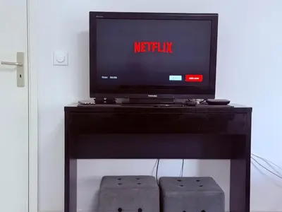 a tv sitting on top of a black entertainment center at Central place close to the beach AC air , WI FI, parking in Nice