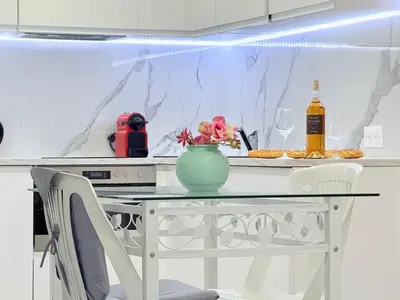 a white kitchen with a table with a vase with flowers at Central place close to the beach AC air , WI FI, parking in Nice