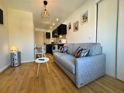 a living room with a couch and a table at APartHotel Riviera - COCON DE LA LIBERTE - Grimaldi - Promenade des Anglais in Nice