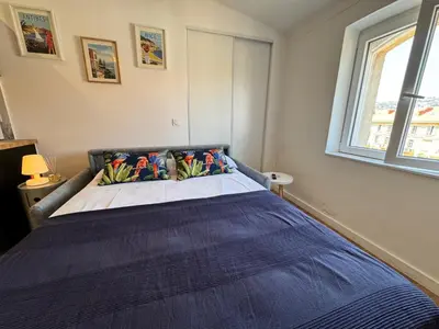 a bedroom with a bed with a blue blanket at APartHotel Riviera - COCON DE LA LIBERTE - Grimaldi - Promenade des Anglais in Nice