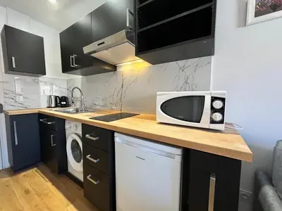 a kitchen with a microwave on top of a counter at APartHotel Riviera - COCON DE LA LIBERTE - Grimaldi - Promenade des Anglais in Nice