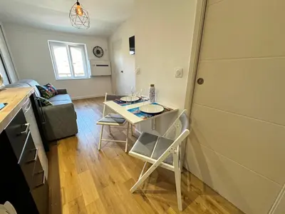 a small kitchen with a table and chairs in a room at APartHotel Riviera - COCON DE LA LIBERTE - Grimaldi - Promenade des Anglais in Nice