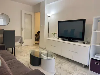 a living room with a flat screen tv on a white cabinet at Superbe 3 pièces près du Port de Nice in Nice