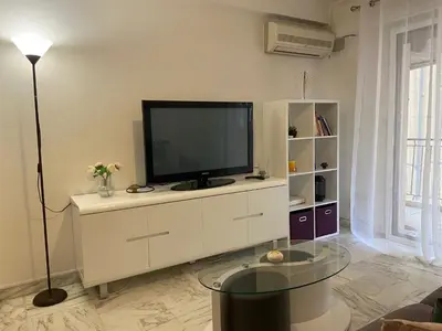 a living room with a television on a white cabinet at Superbe 3 pièces près du Port de Nice in Nice