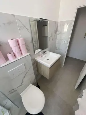 a white bathroom with a toilet and a sink at Cosy flat 250m from beach in Nice