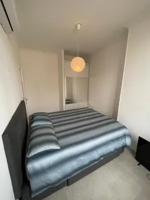 a bed in a small room with a light at Cosy flat 250m from beach in Nice