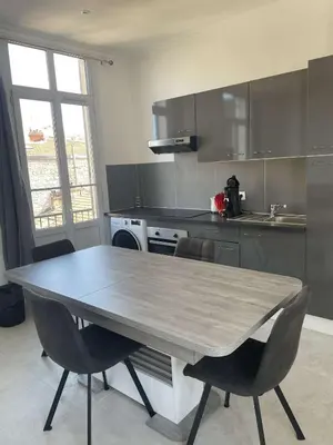 a kitchen with a table and chairs in a kitchen at Cosy flat 250m from beach in Nice