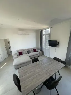 a living room with a wooden table and a couch at Cosy flat 250m from beach in Nice