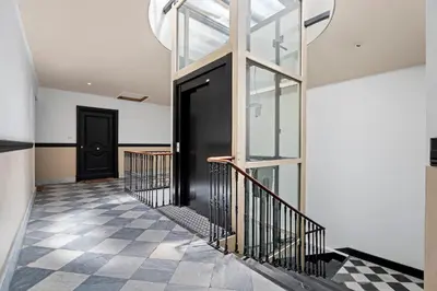 a hallway with a black door and a checkered floor at Nice Renting - 3 MASSENA - Chic Escape Luxury Duplex Place Massena in Nice