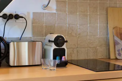 a coffee maker sitting on a counter next to glasses at Nice Renting - 3 MASSENA - Chic Escape Luxury Duplex Place Massena in Nice