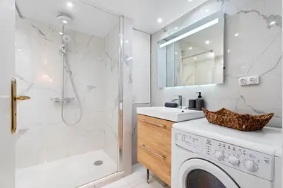 a bathroom with a washing machine and a shower at Nice Renting - 3 MASSENA - Chic Escape Luxury Duplex Place Massena in Nice