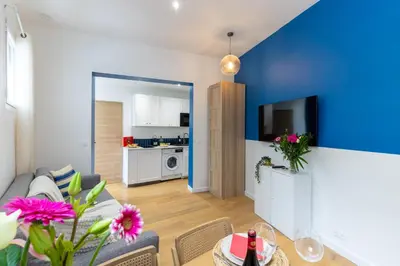 a living room with a blue accent wall at Lavie Maison Sauna and Hot Tub Seaside in Nice