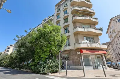 a tall building with a tree in front of it at Lavie Maison Sauna and Hot Tub Seaside in Nice