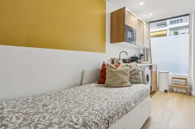 a bedroom with a bed and a yellow wall at Lavie Maison Hot Tub Seaside Studio in Nice