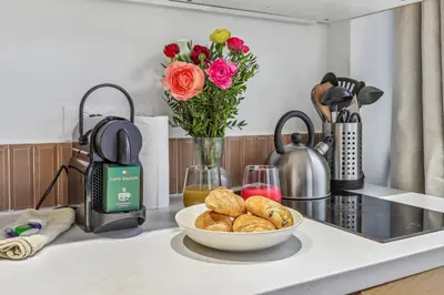 a table with a bowl of bread and a vase of flowers at Lavie Maison Hot Tub Seaside Studio in Nice