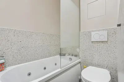 a bathroom with a tub and a toilet and a sink at Lavie Maison Hot Tub Seaside Studio in Nice