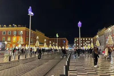 a group of people walking down a street at night at Chez Yaya in Nice