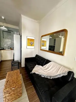 a living room with a black couch and a mirror at Chez Yaya in Nice