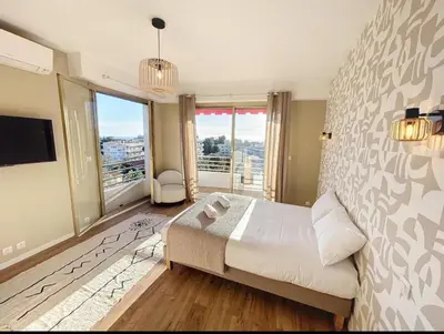 a bedroom with a large bed and a large window at Spacieux appartement à Nice 4 chambres in Nice