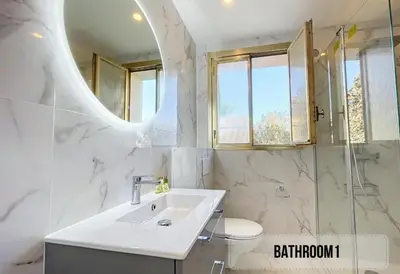 a white bathroom with a sink and a mirror at Spacieux appartement à Nice 4 chambres in Nice