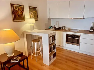 a kitchen with a counter and a table with a stool at Nice SuiteMarie Carre d'or in Nice