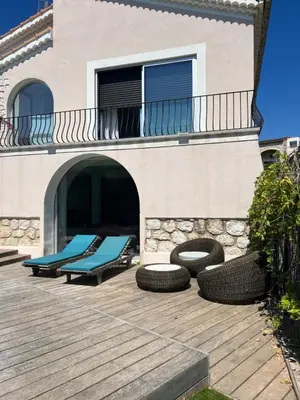 a patio with two lounge chairs and a building at Superbe villa piscine proche ville et mer au calme in Nice