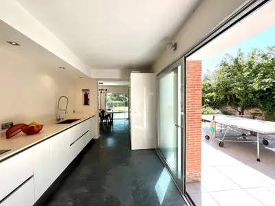 a kitchen with a large sliding glass door leading to a patio at Superbe villa piscine proche ville et mer au calme in Nice