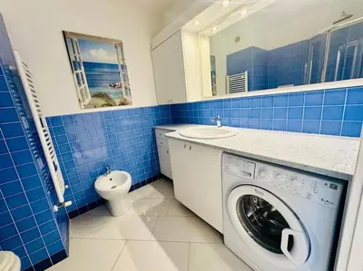 a blue and white bathroom with a washing machine at Art de vivre sur la Promenade in Nice