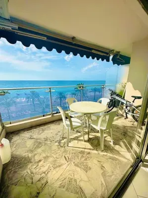 a balcony with a table and chairs and the ocean at Art de vivre sur la Promenade in Nice