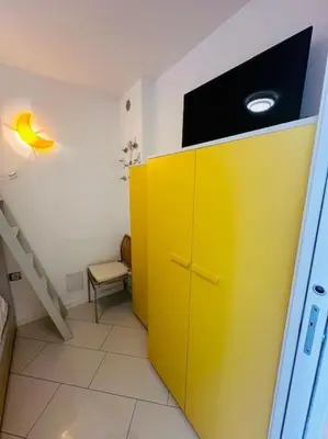 a yellow cabinet with a television on top of it at Art de vivre sur la Promenade in Nice