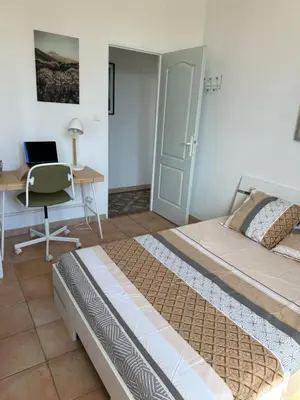 a bedroom with two beds and a desk with a laptop at Maison de ville à Nice Ouest dans propriété arborée in Nice