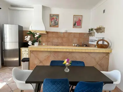 a kitchen with a dining table and blue chairs at Maison de ville à Nice Ouest dans propriété arborée in Nice