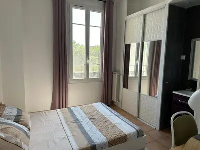 a bedroom with a bed and a window at Maison de ville à Nice Ouest dans propriété arborée in Nice
