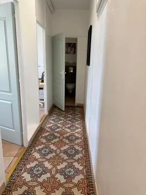 a hallway with a tile floor and a bathroom at Maison de ville à Nice Ouest dans propriété arborée in Nice