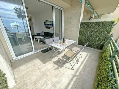 a patio with a table and chairs on a balcony at Gorgeous Oceanfront Apartment Promenade in Nice