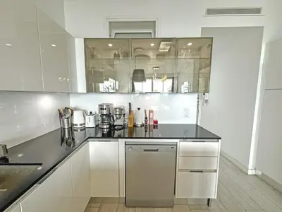 a kitchen with white cabinets and a black counter top at Gorgeous Oceanfront Apartment Promenade in Nice