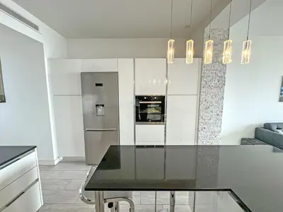 a kitchen with a table and a refrigerator at Gorgeous Oceanfront Apartment Promenade in Nice
